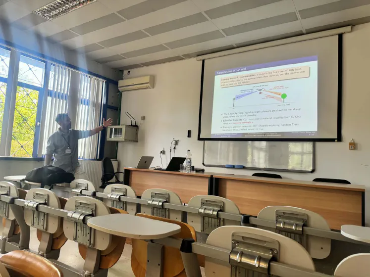 Evangelos Vlachos explaining the contributions slide at NextGCom 2026